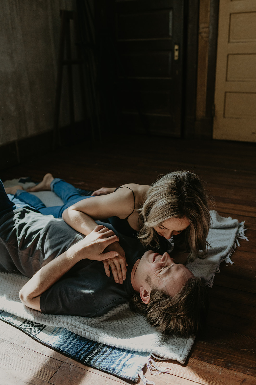 A couple cuddles in an intimate loft space engagement session in Vermilion Alberta.