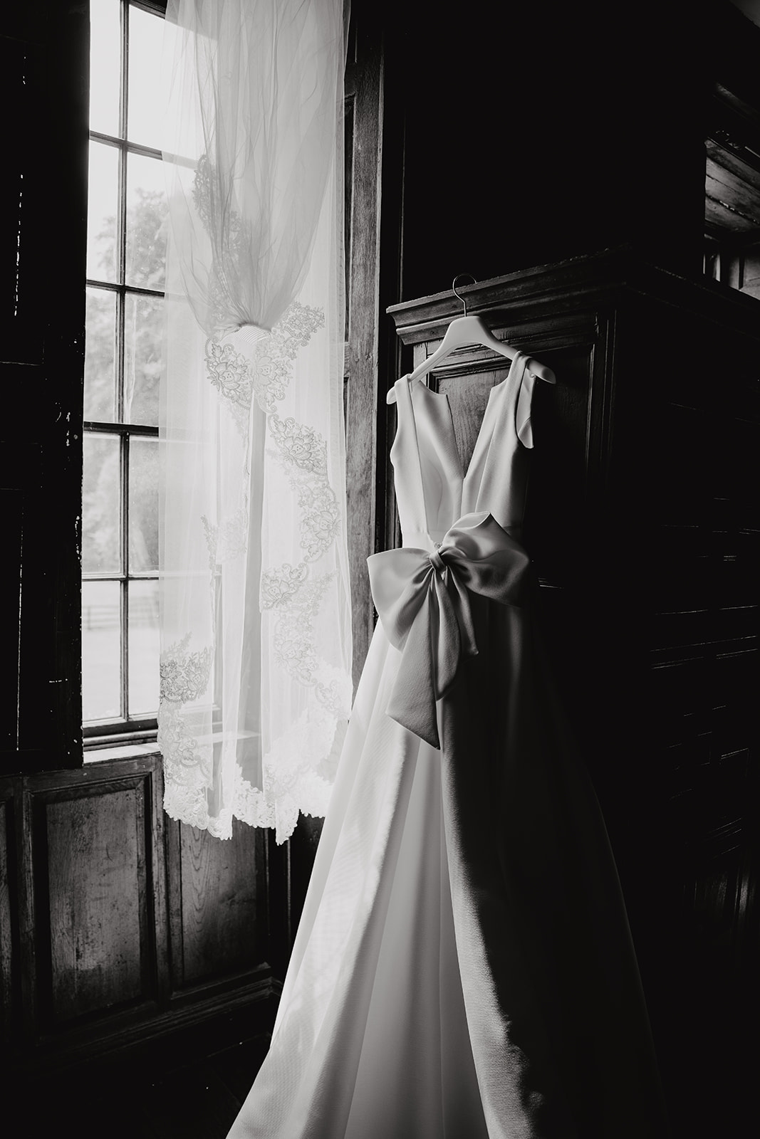Back and white detail of the wedding dress hanging, showing the beautiful bow detail on the back.