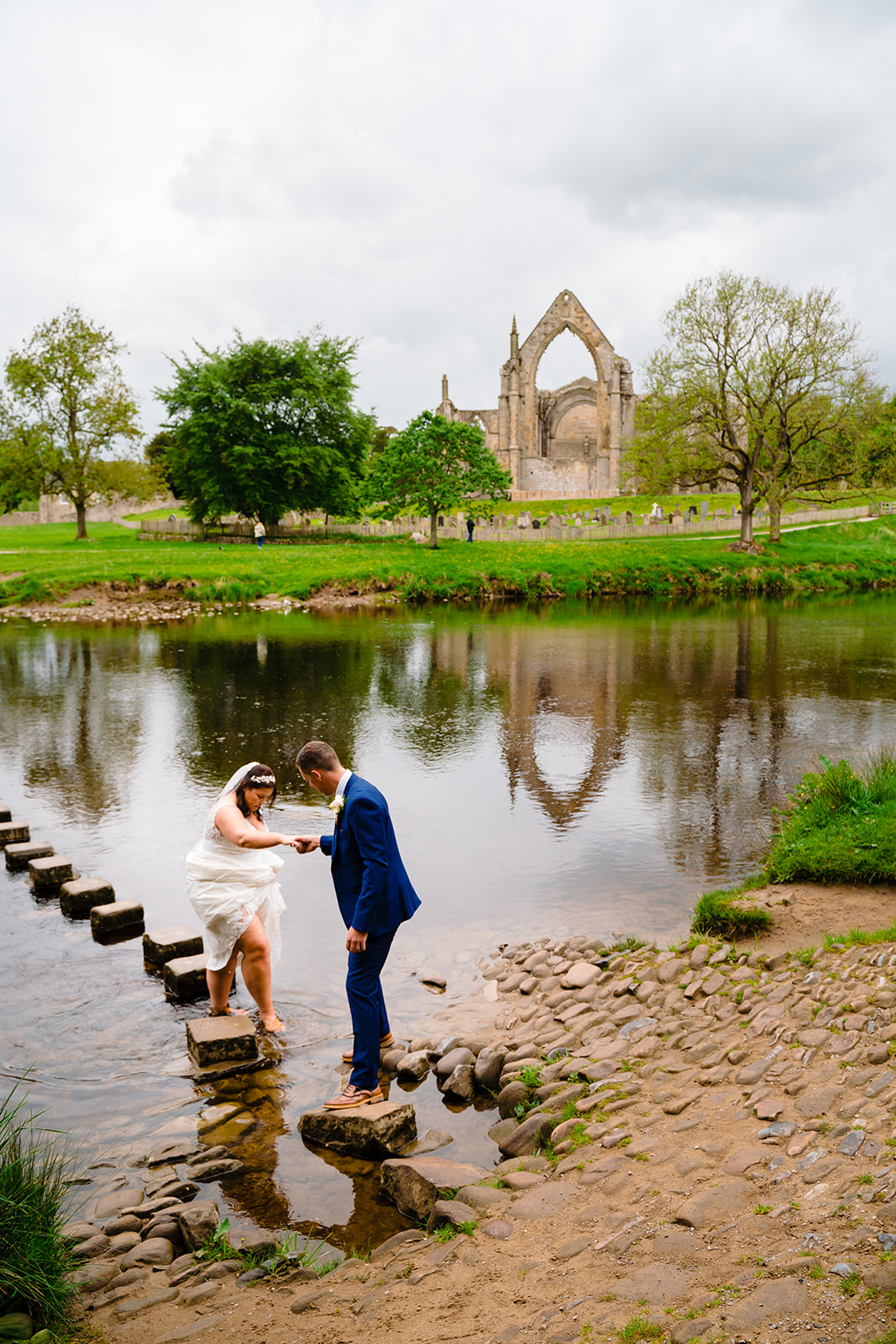 a couple on the stepping stones at Bolton Abbey