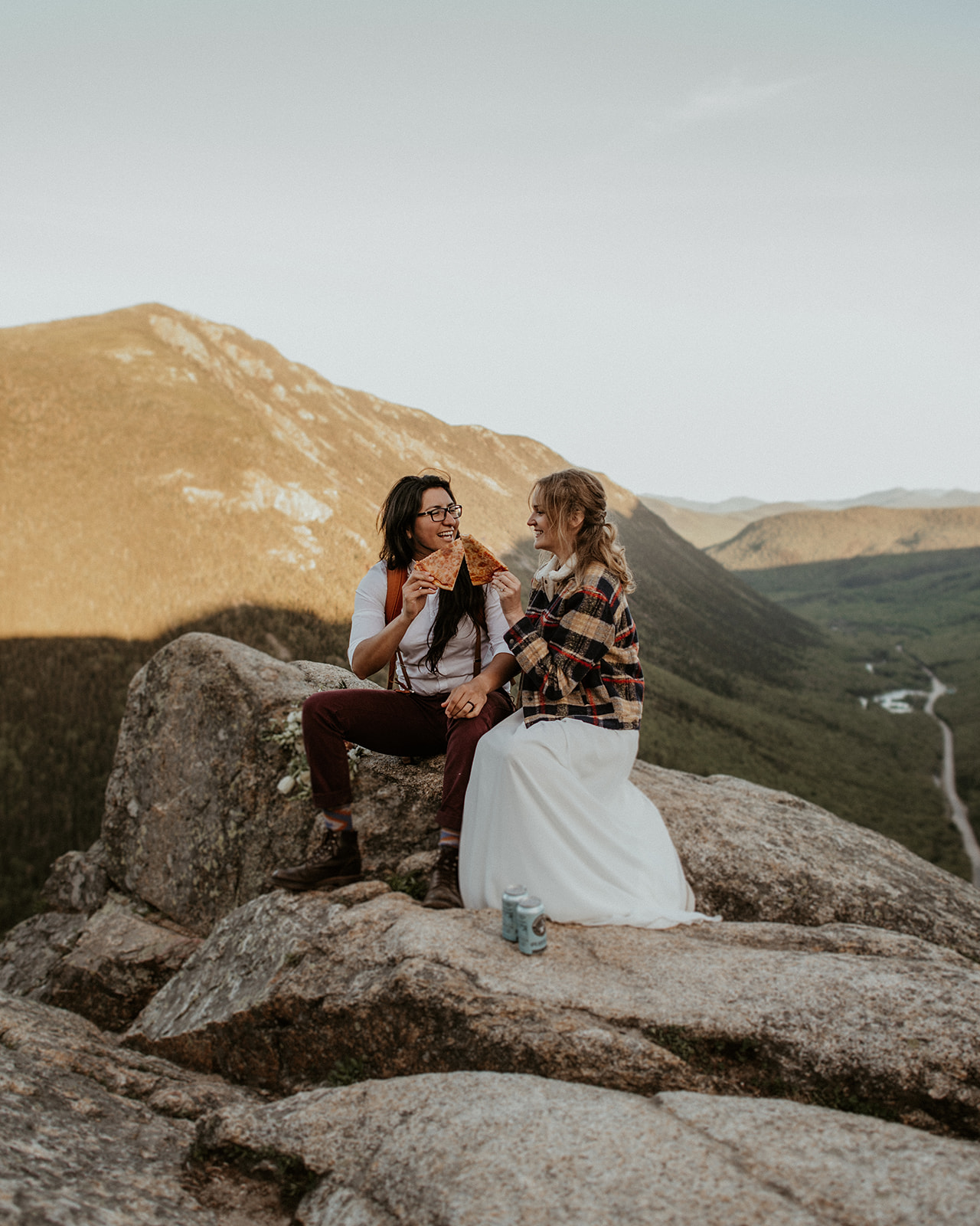 Brides share pizza and beer during their White Mountains Elopement