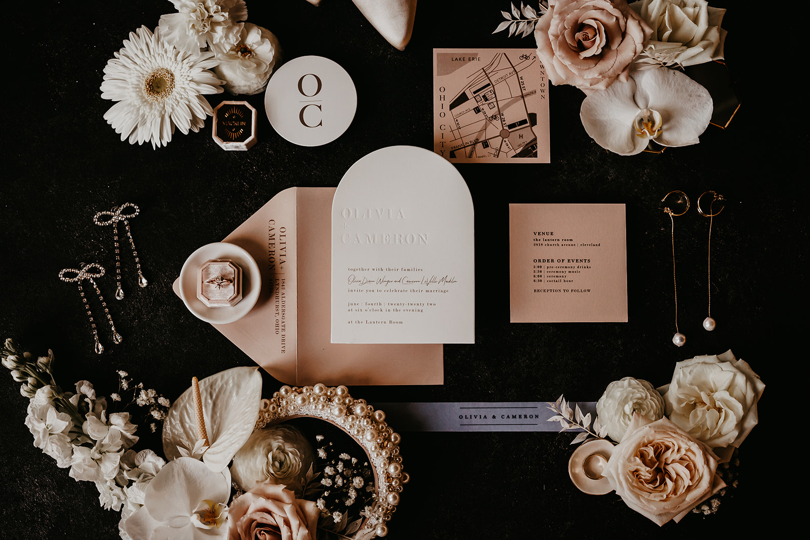 Artfully composed flat lay capturing the elegant wedding invitations, rings, and floral arrangements - setting the tone 