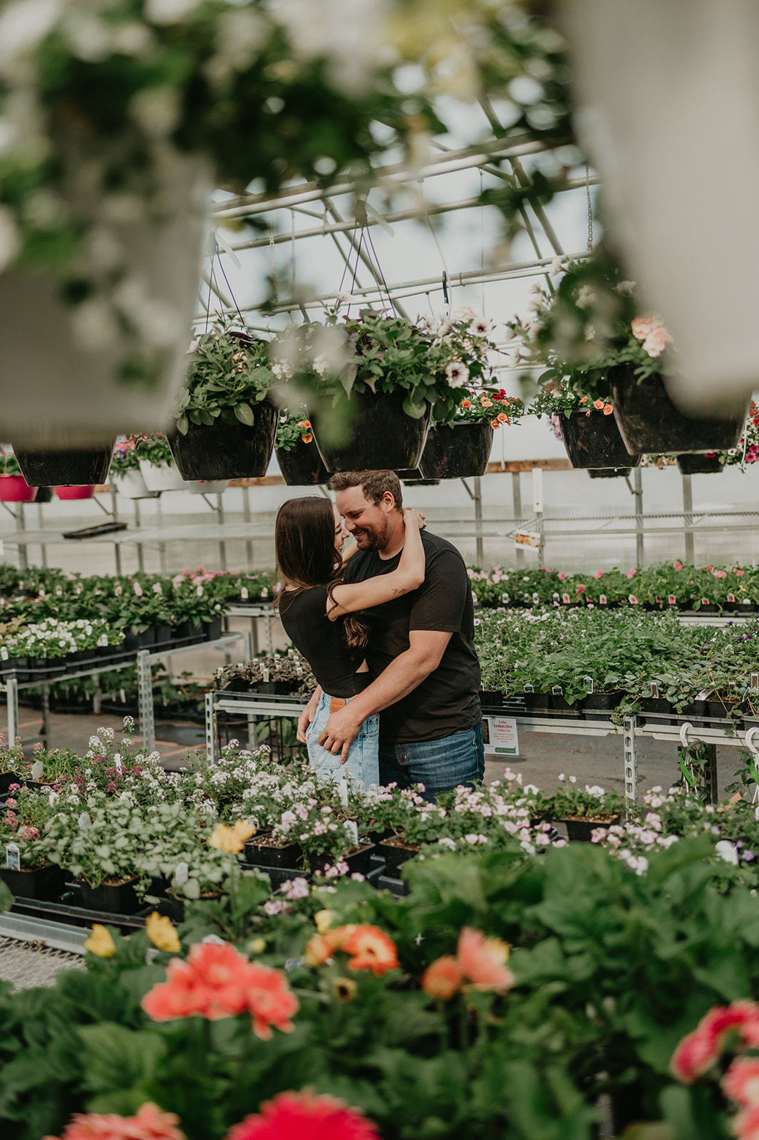 A couple embraces during their Vermilion greenhouse engagement session.