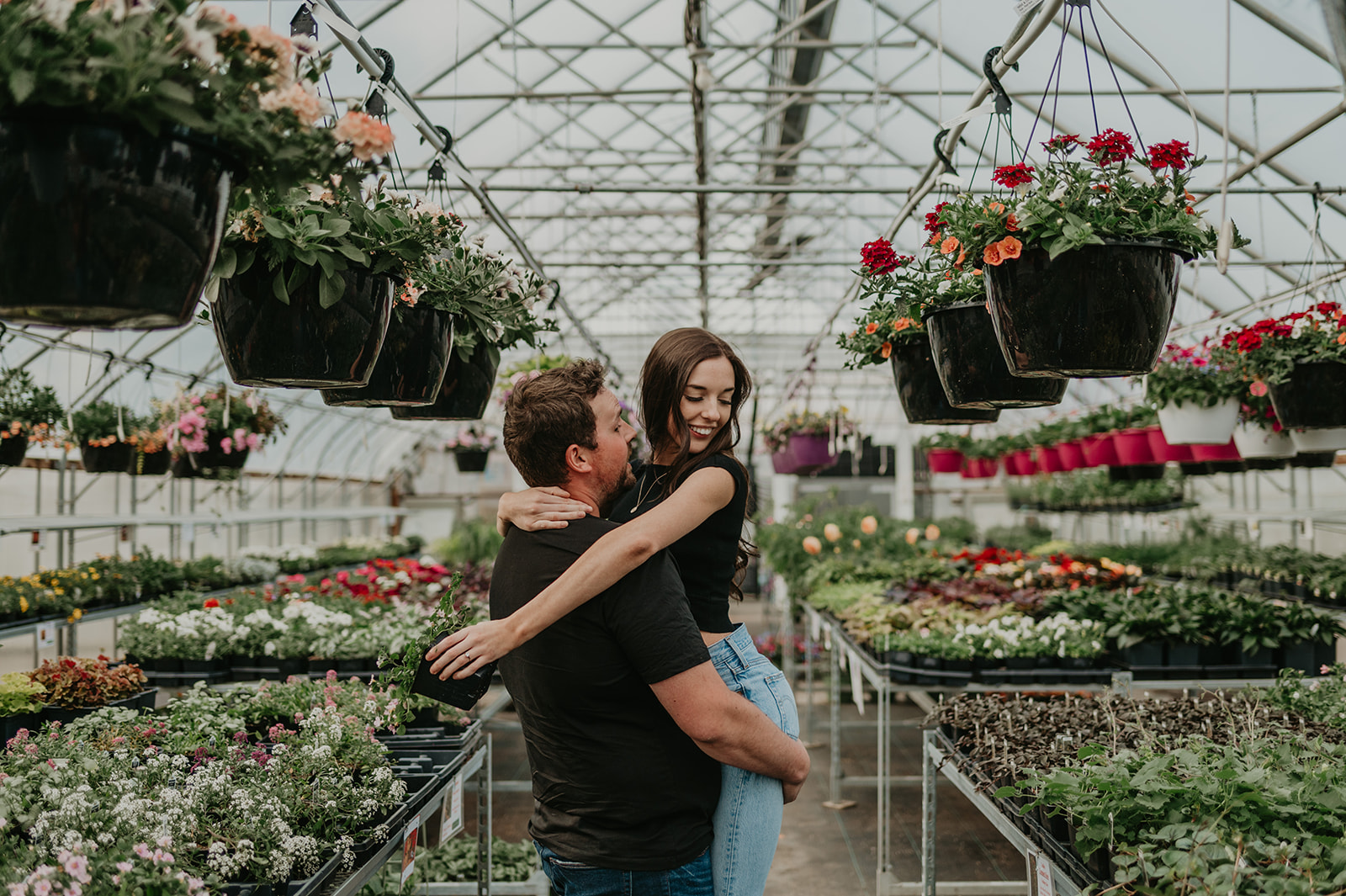 A couple laughs in a greenhouse at their Vermilion engagement session.