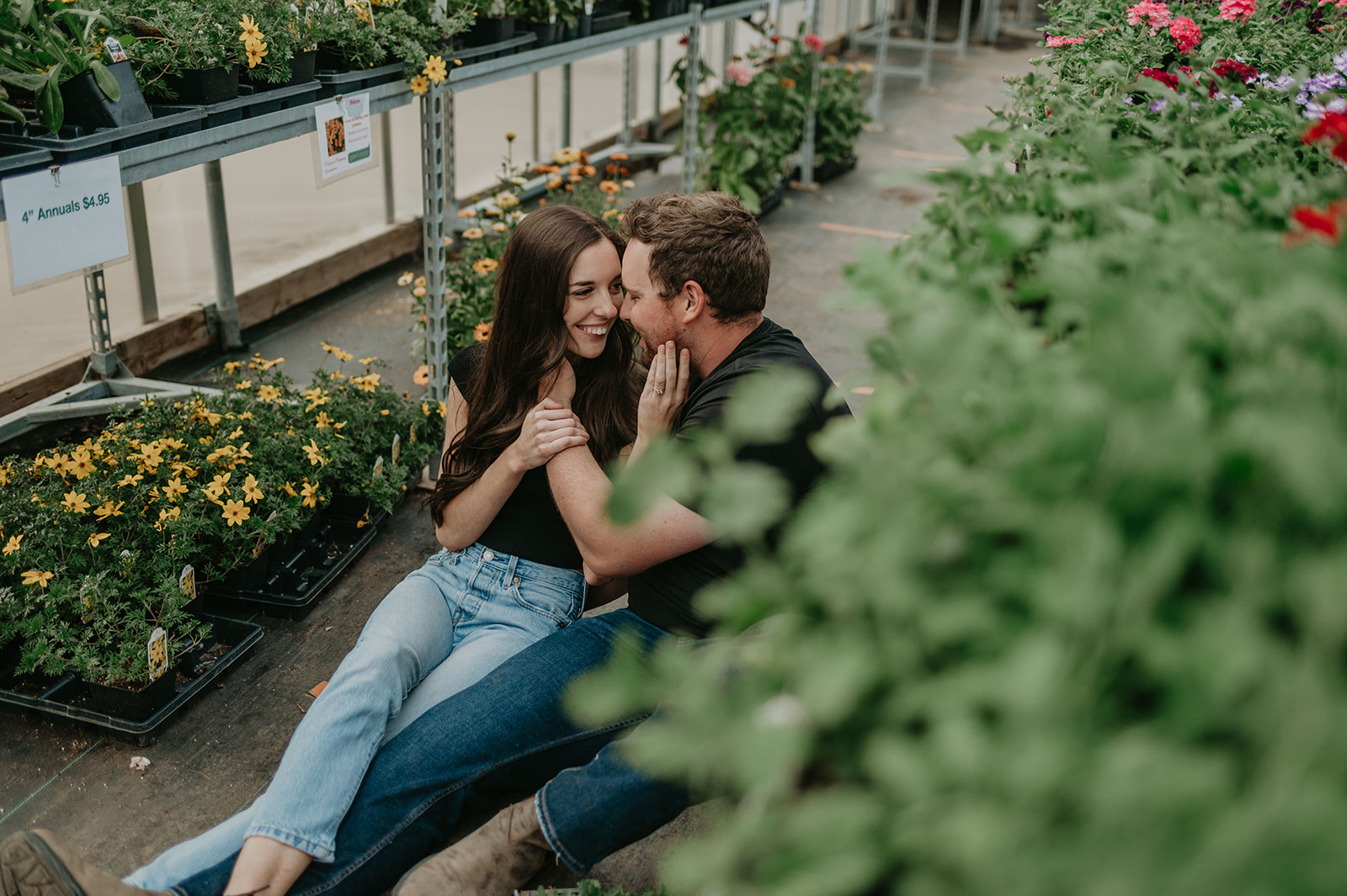 A couple laughs in a greenhouse at their Vermilion engagement session.