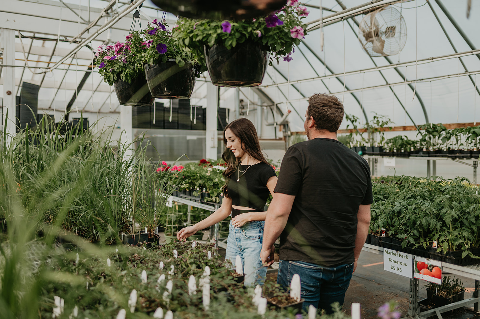 A couple shops together at their greenhouse engagement session.
