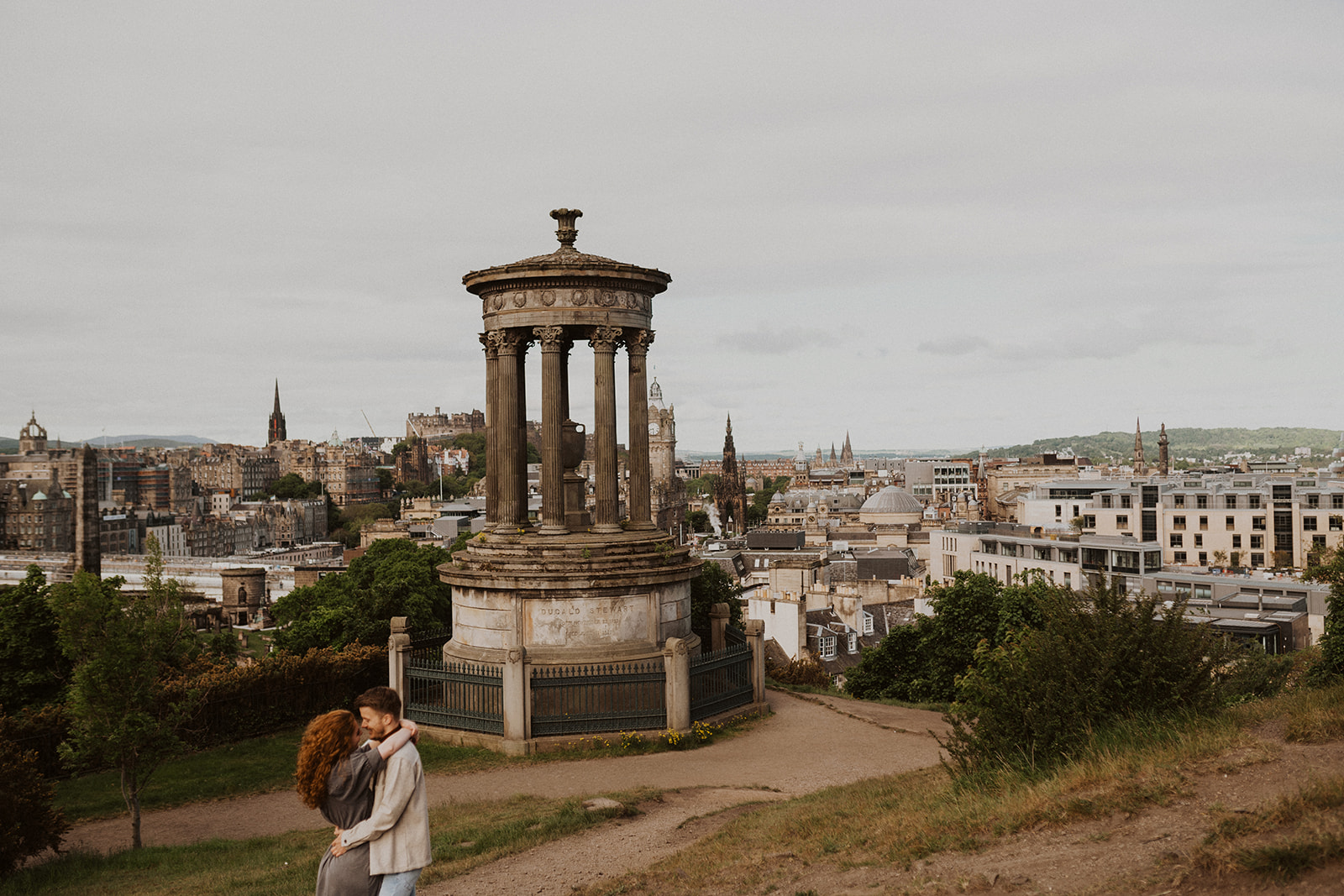Couple kiss at Calton Hill in Edinburgh during photography session with Tamar Hope Photography