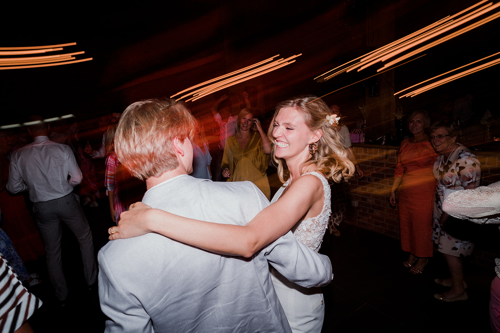 bruid lacht met haar broer terwijl ze dansen