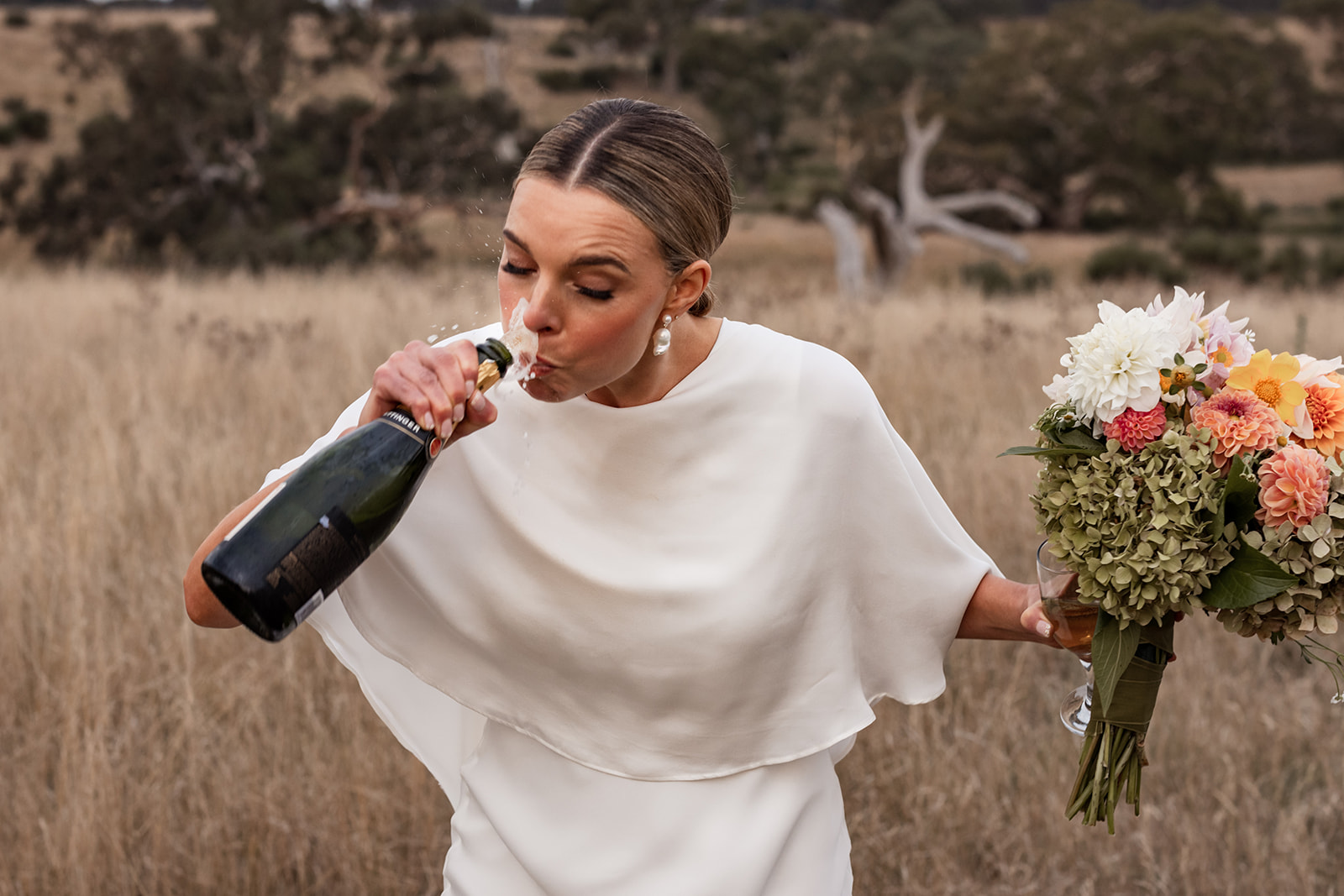 A Bride spills some champagne while taking a drink