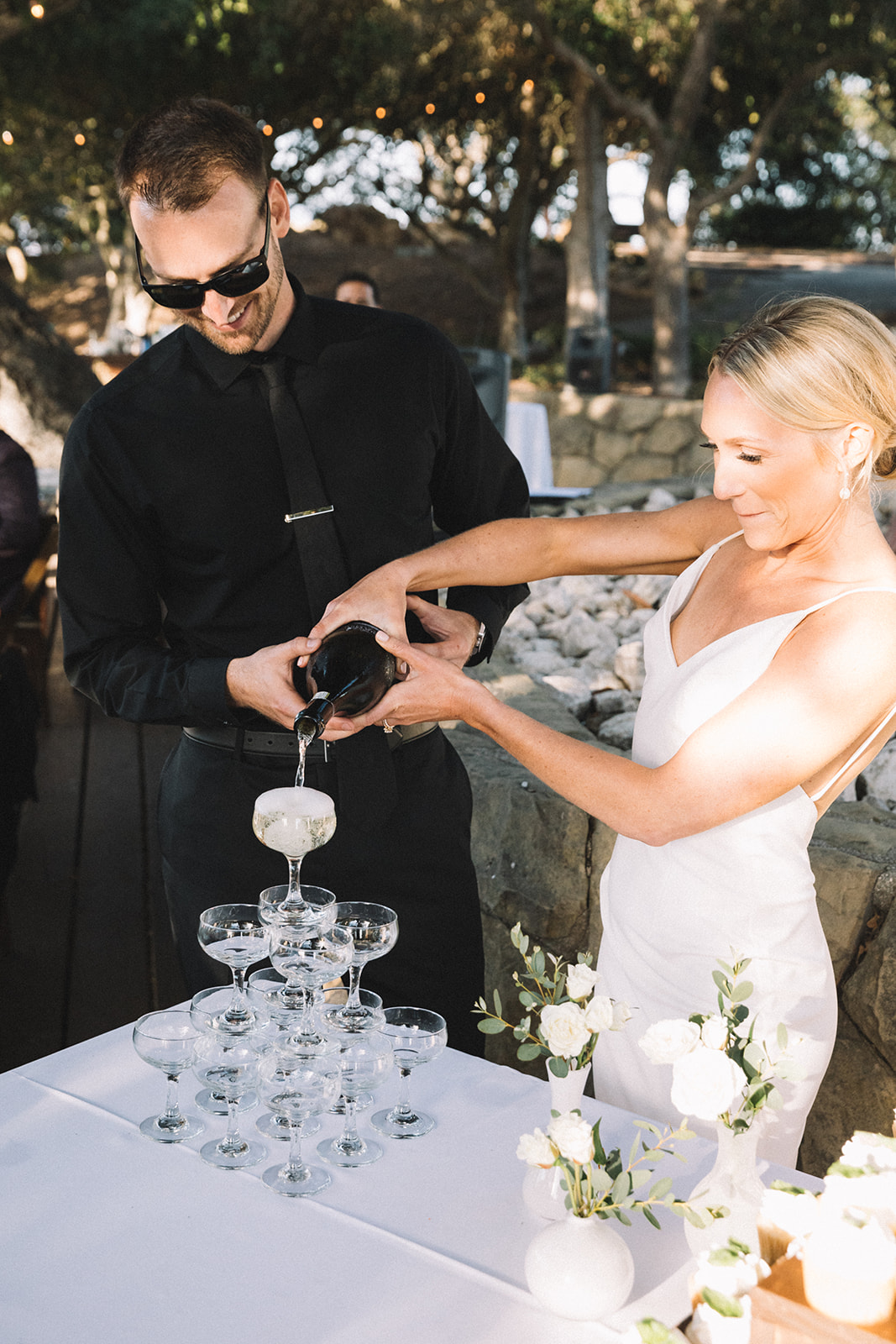 Couple pours champagne tower to toast each other at their Elings Park Santa Barbara wedding. 