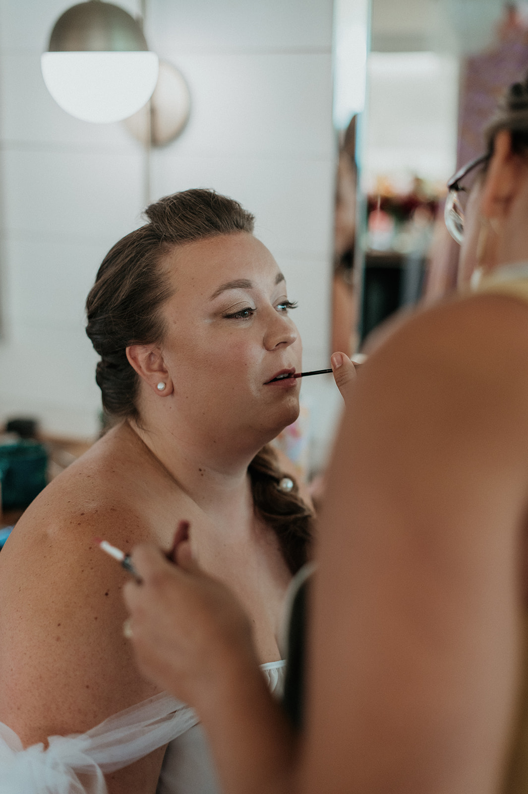 Bride having lipgloss applied