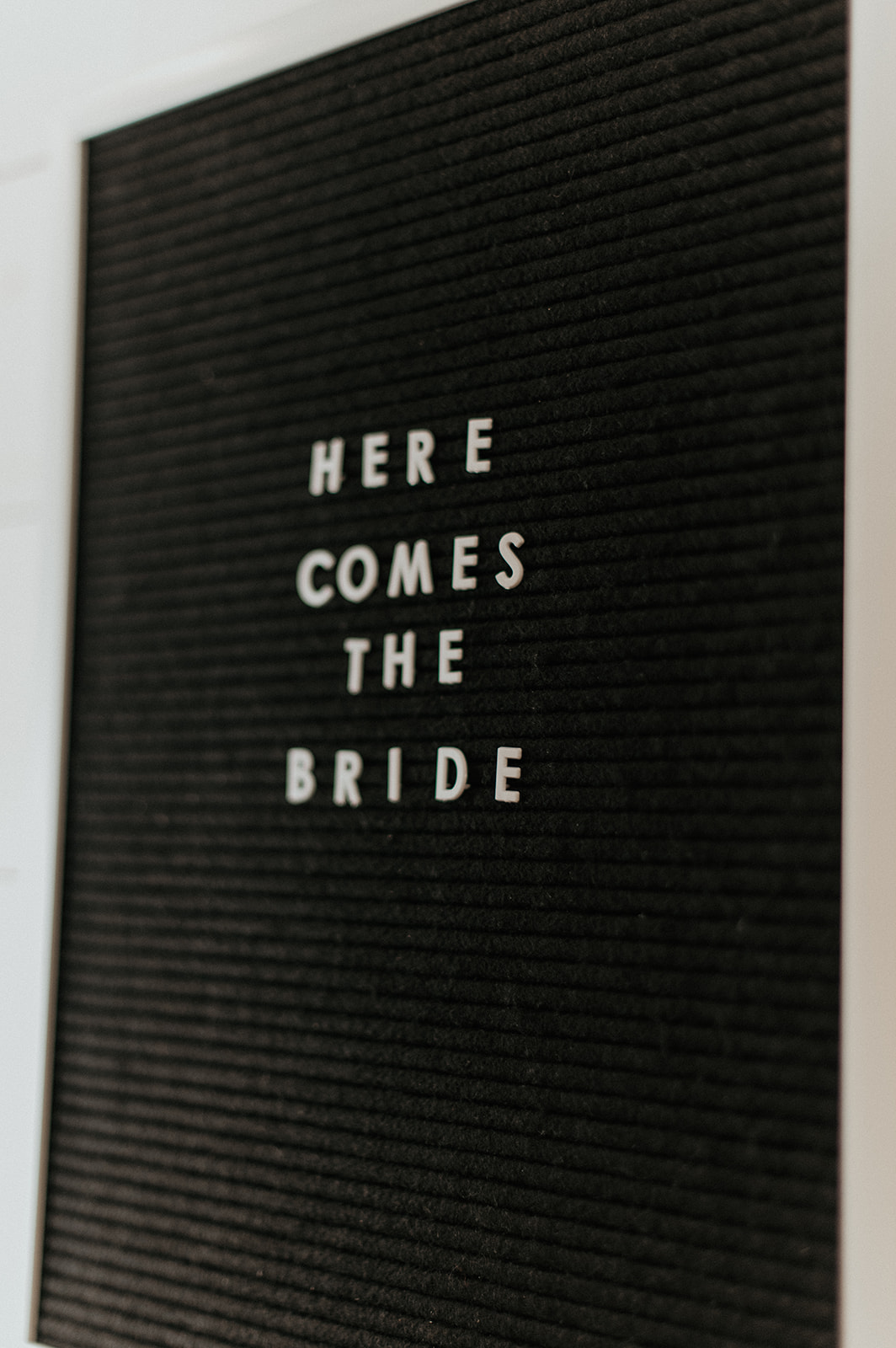 Letterboard saying here comes the bride
