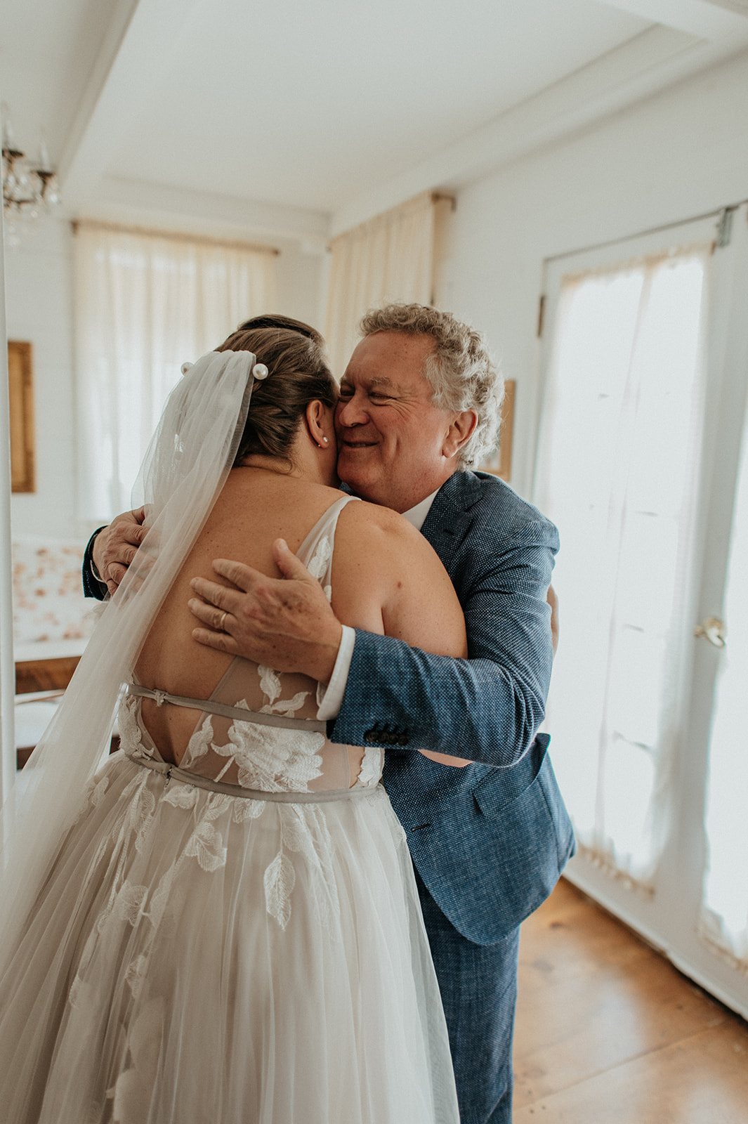 Father of the bride embraces bride 