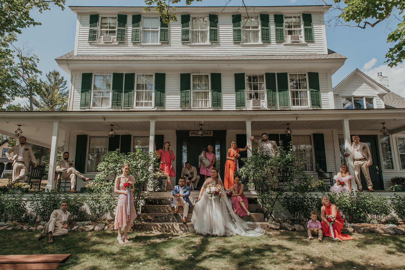Wedding party with bride and groom pose for portrait on main house at The Preserve at Chocorua