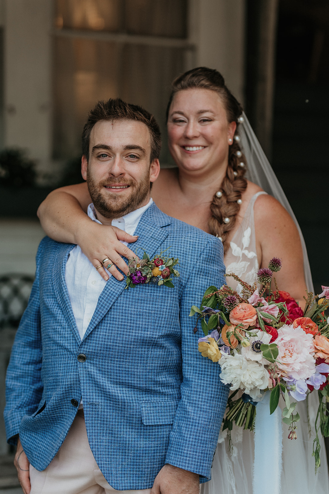 Bride and groom smile at camera together during portraits
