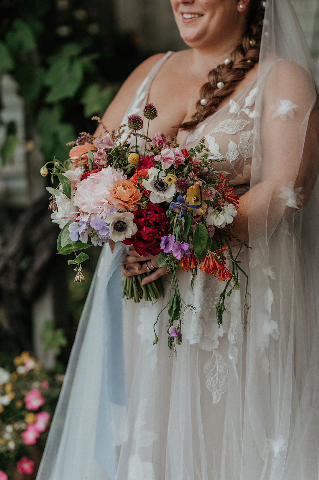 Detail photo of bride holding bouquet with Willow by Watters gown