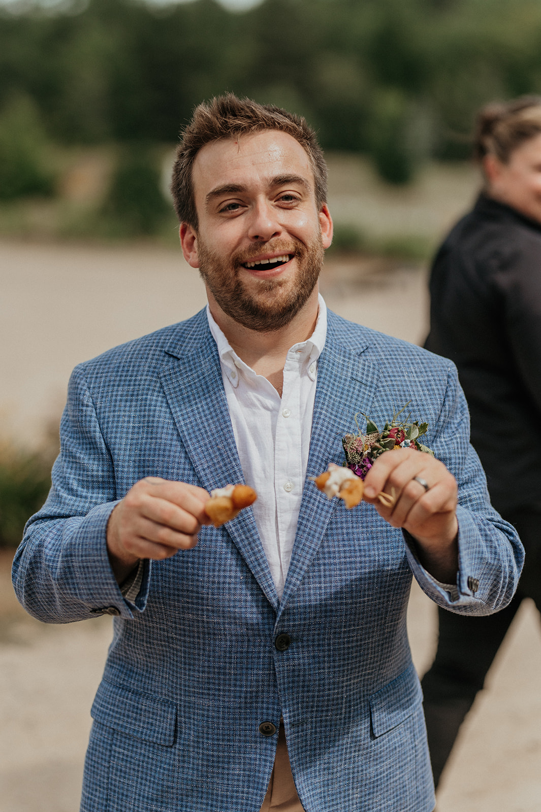 Groom laughing holding appetizers