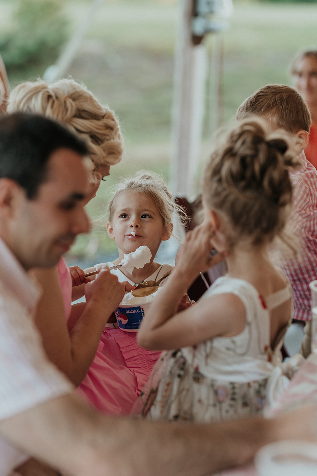 Flower girl eats cool whip during wedding reception