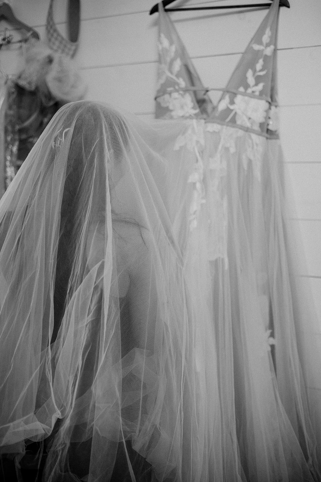 Black and white image of bridesmaid steaming Willow by Watters wedding gown