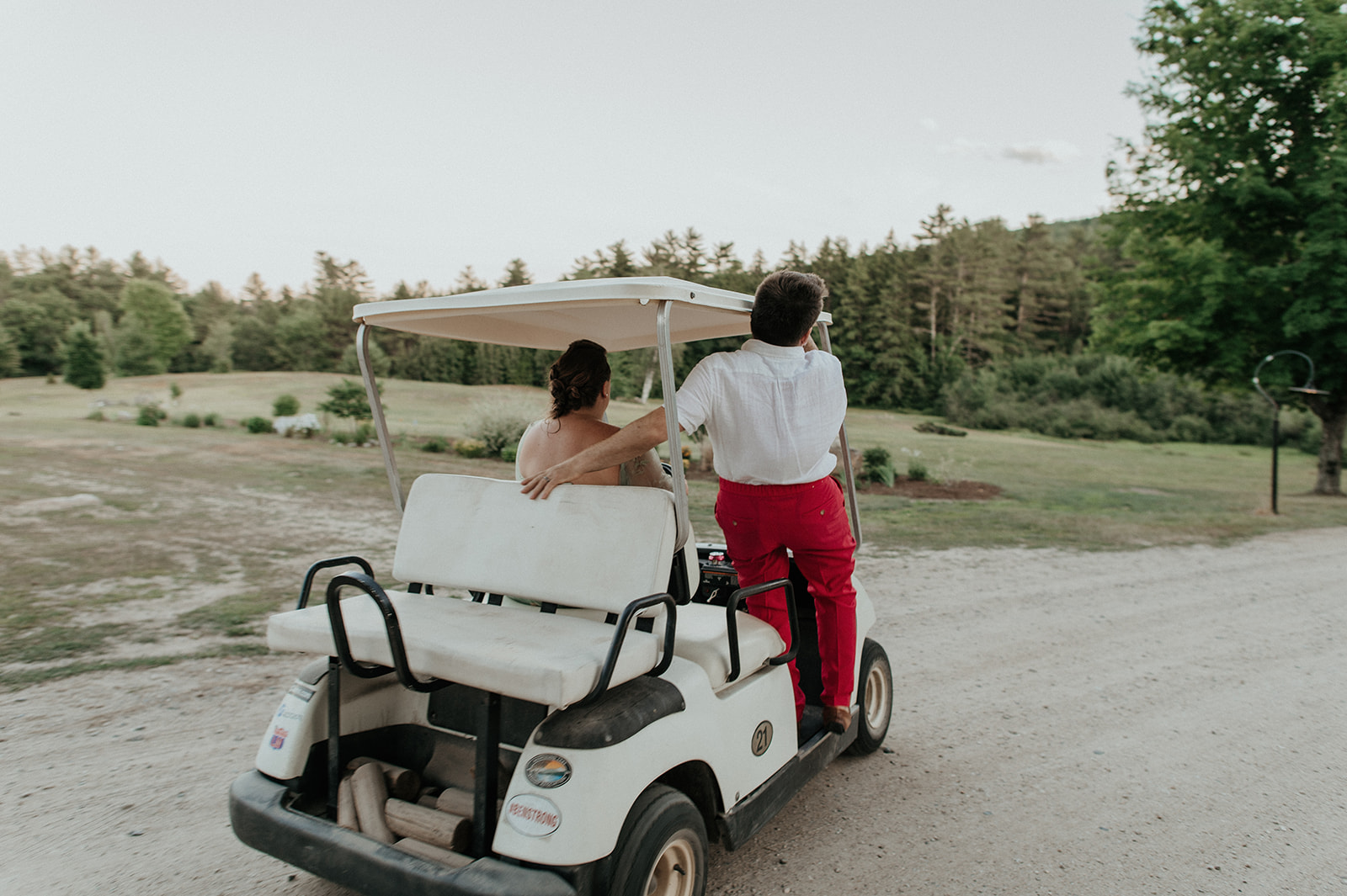 Bride and groom riding on golf cart