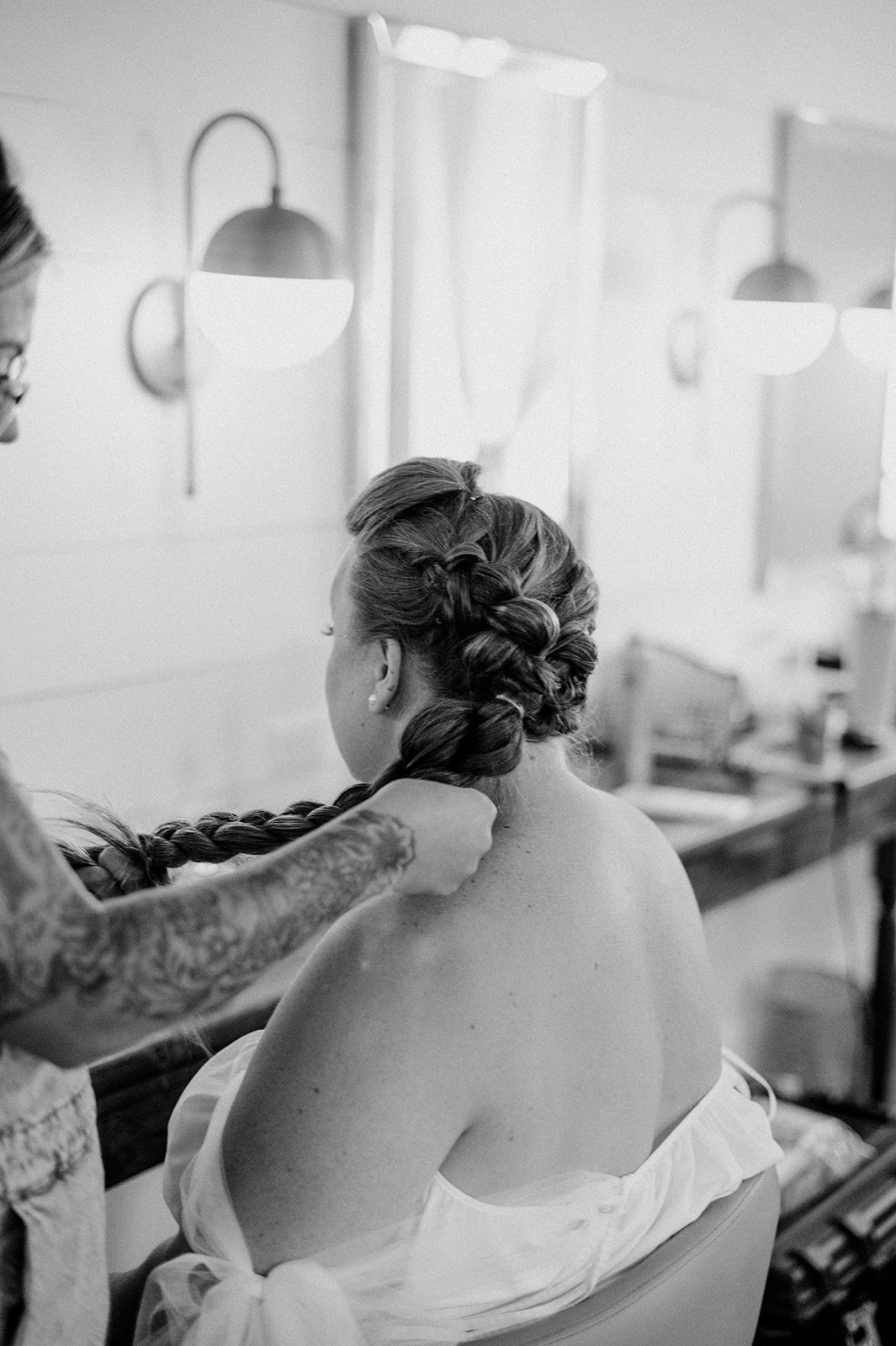 Black and white image of bride having her hair styled
