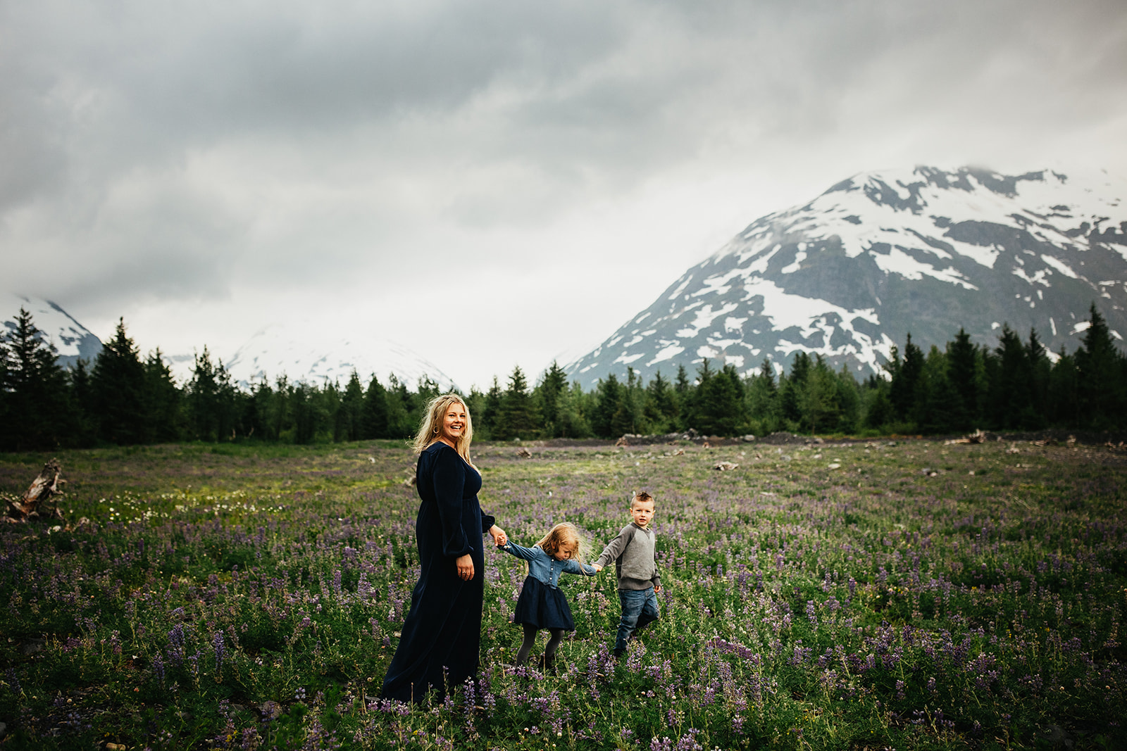 A mom and her kids explore a lupine field near Girdwood, Alaska.