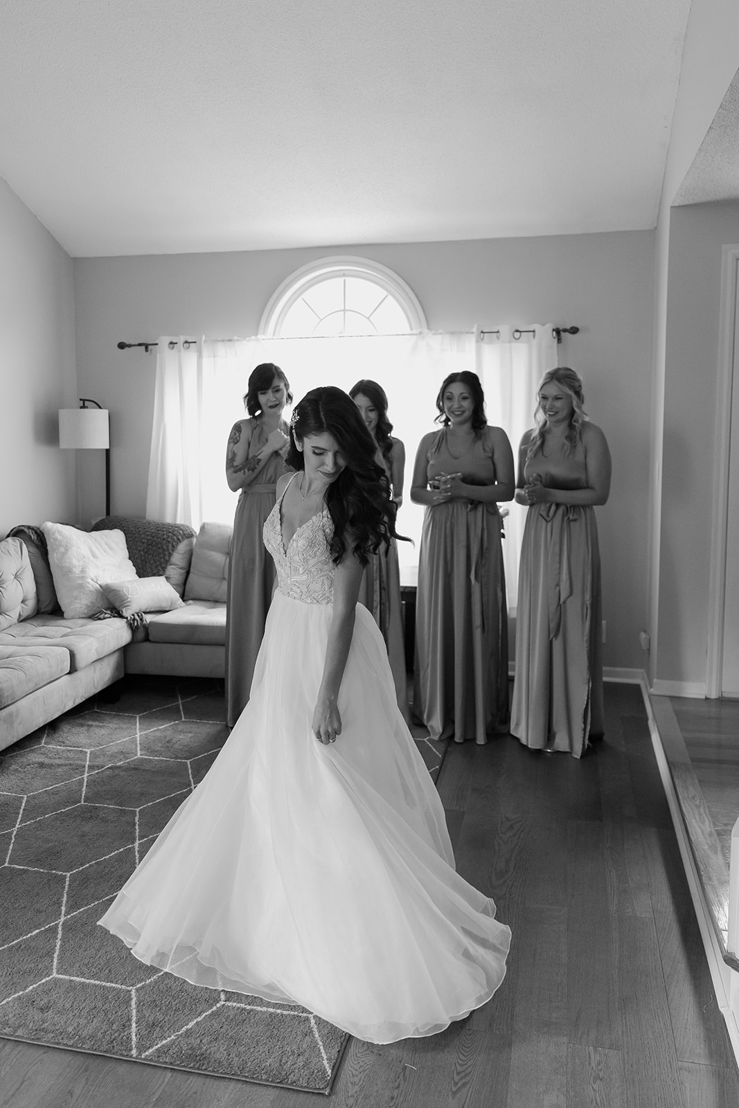 Bride twirls in her dress in front of her bridesmaids