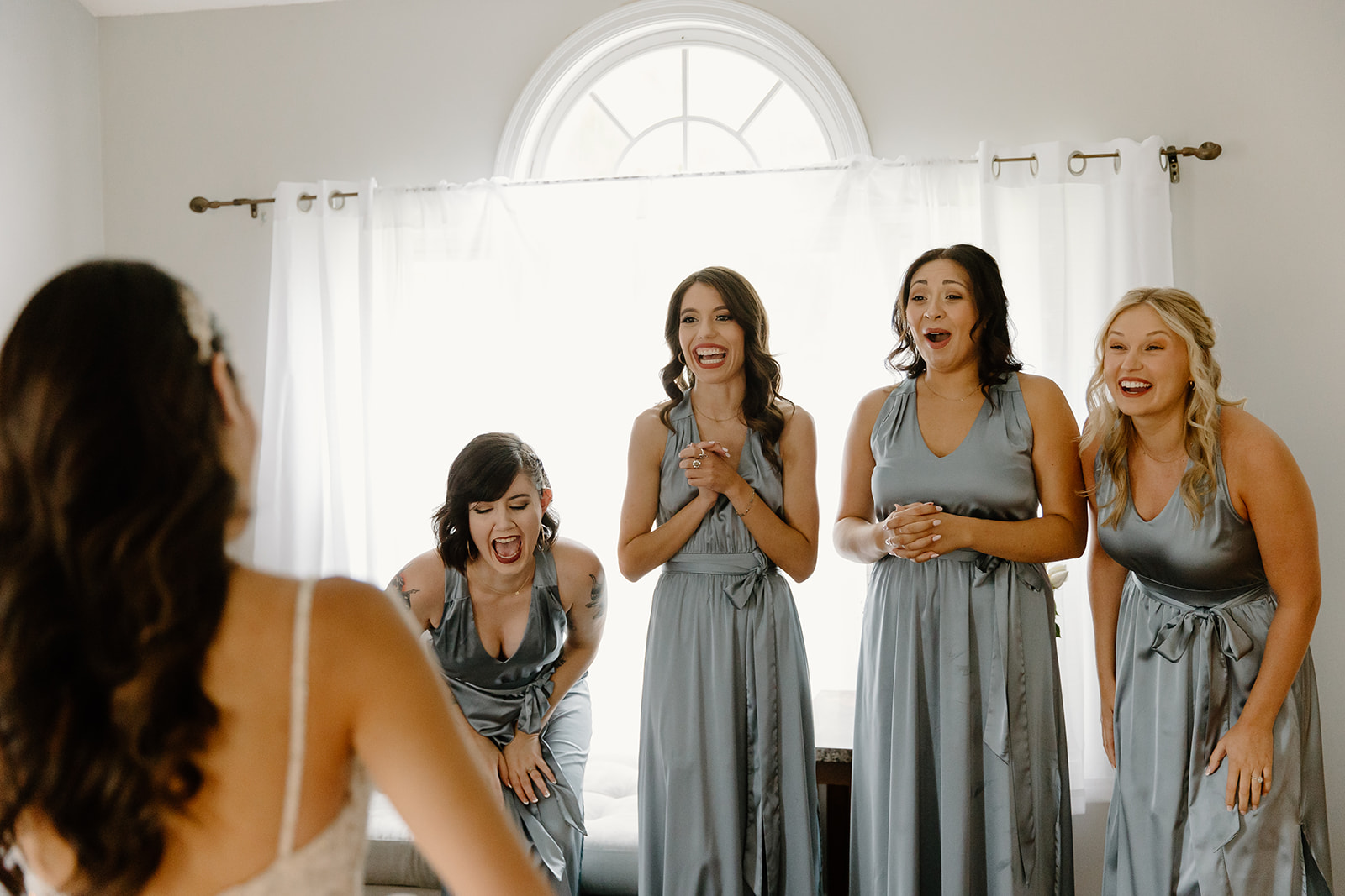 Bridesmaids react to seeing their friend in her wedding dress