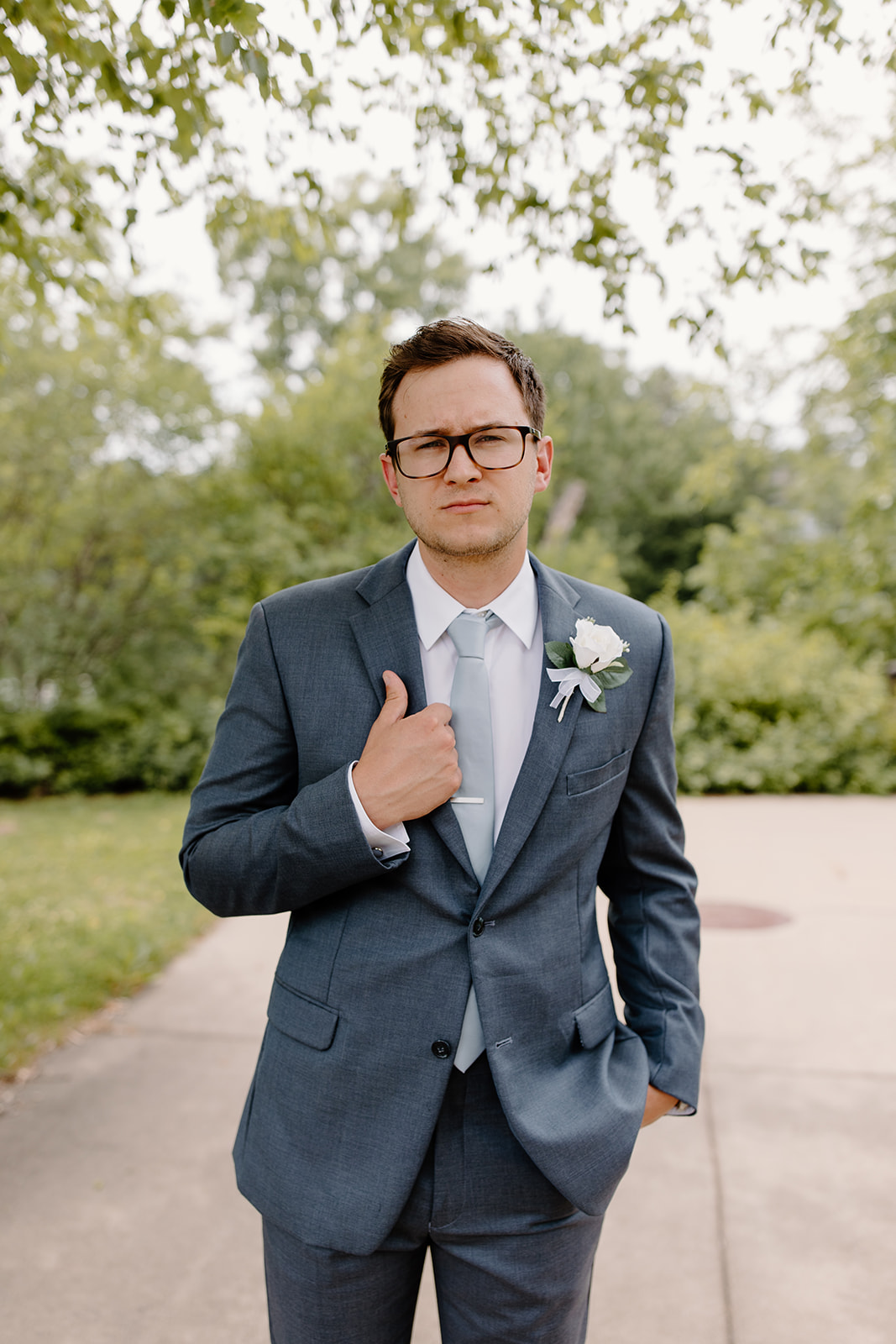 Groom stares into the camera while holding his lapel