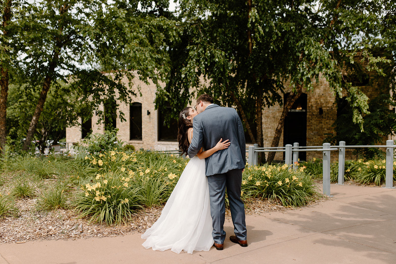 Bride and groom hold each other while looking at their wedding venue