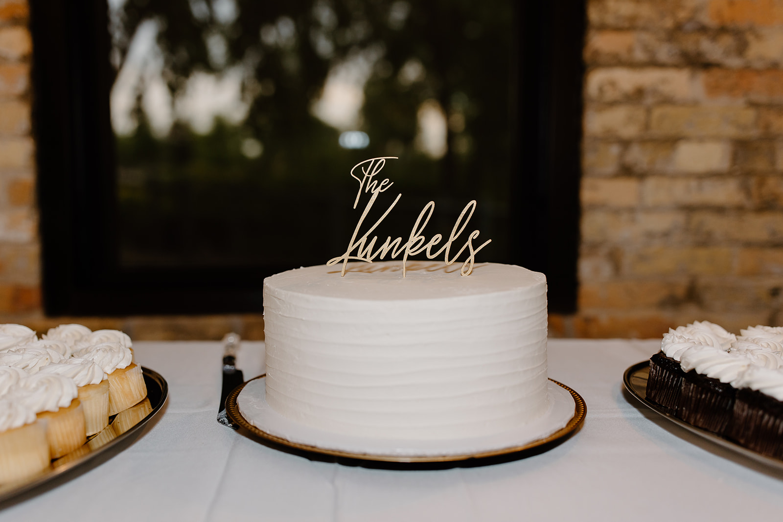 One tier wedding cake with a cake topper of a couple's last name