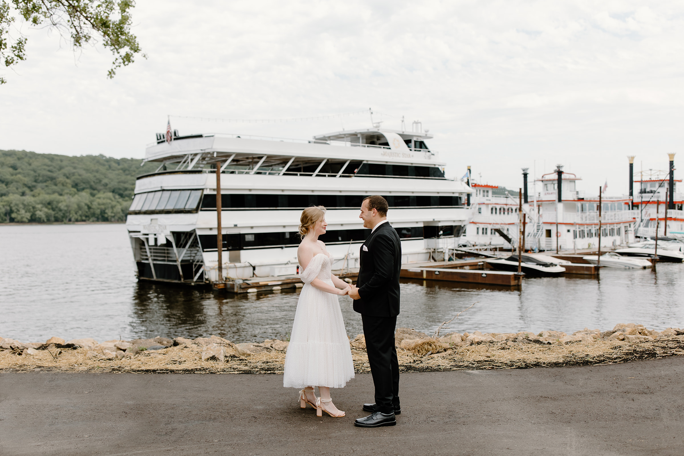Bride and groom hold hands in front of a yacht