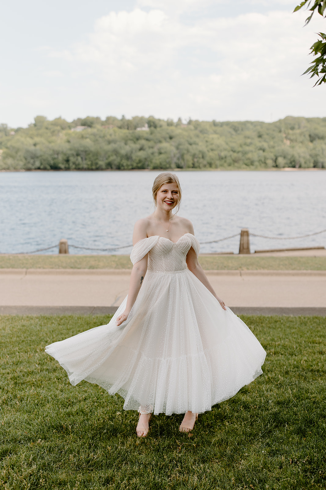 Bride twirling her dress in front of a lift bridge on the St. Croix river