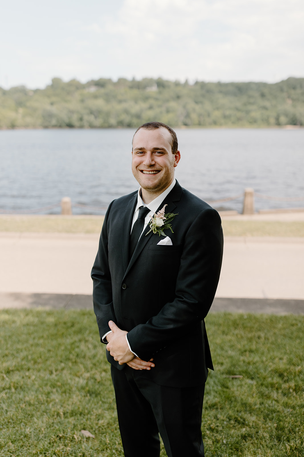 Groom smiling in front of a lift bridge on the St. Croix river