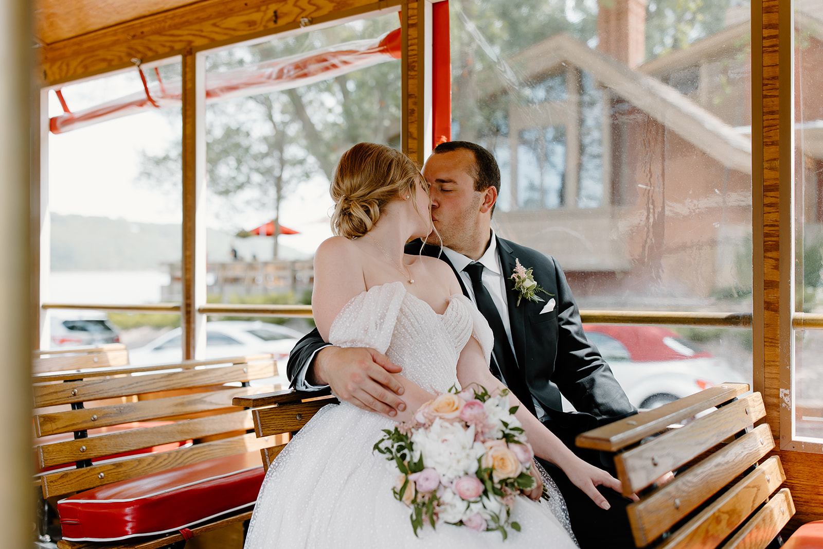 Bride and groom sharing a kiss on a trolley