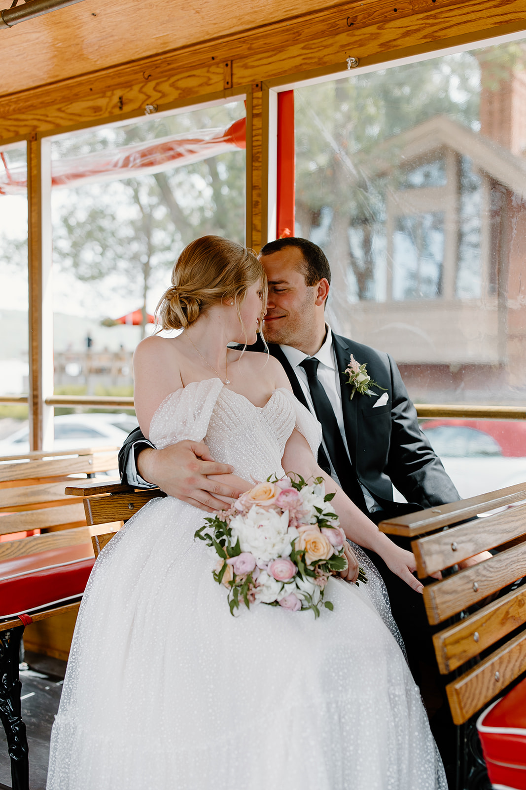 Bride and groom sharing a kiss on a trolley
