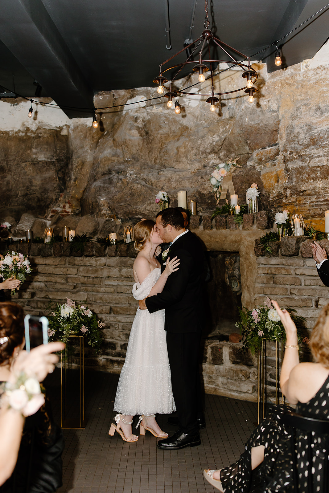 Bride and groom kissing during their ceremony in a cave