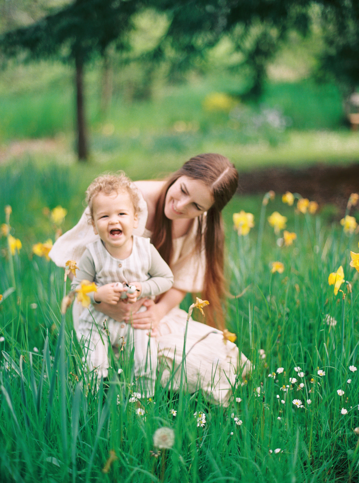 a mom hugs her toddler in a daffodil field in Wilsonville Oregon