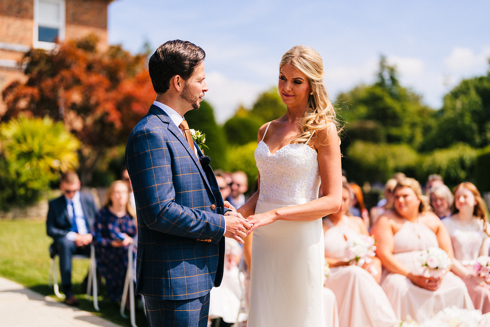  the bride and groom, exchanging wedding rings during an outdoor wedding ceremony