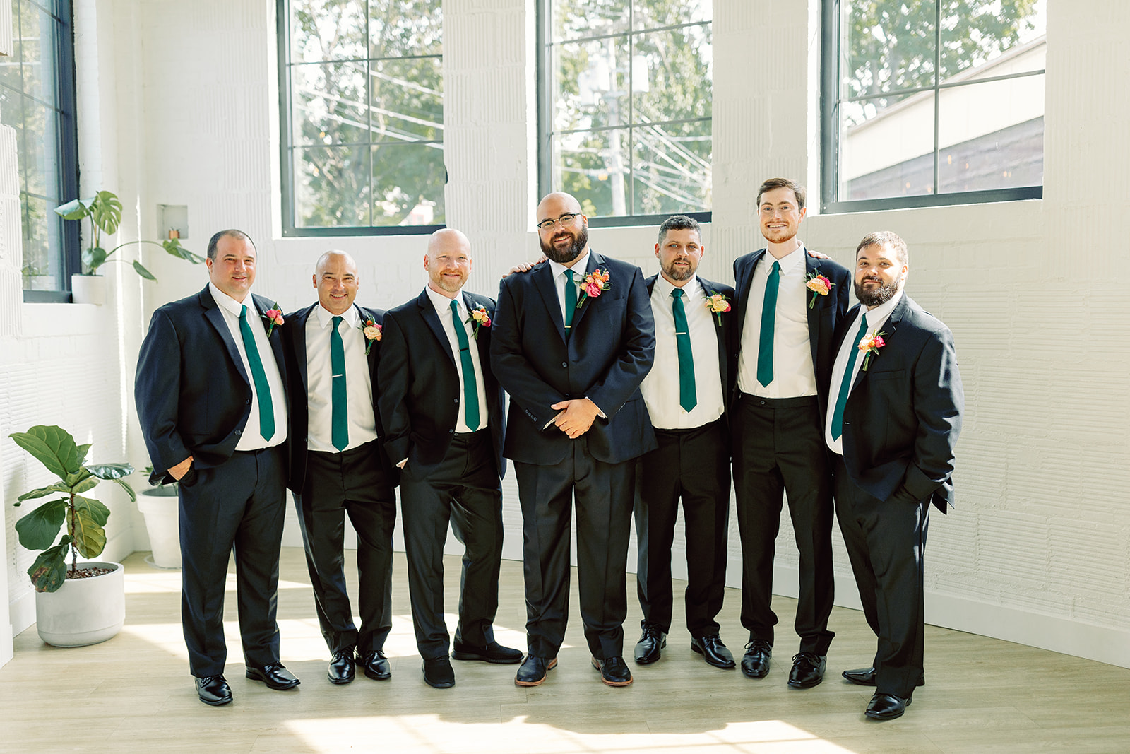 The groomsmen smiling at the camera at The Highline Rochester. 