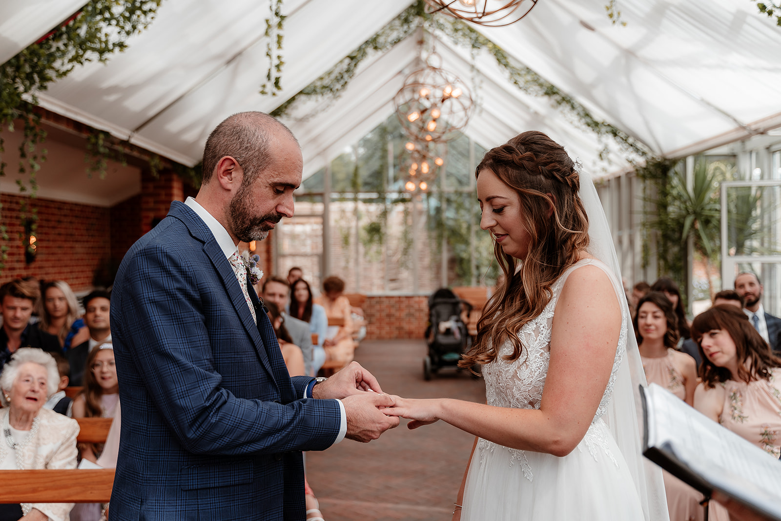 A couple say their vows together in the Glasshouse at their summer Syrencot wedding. 