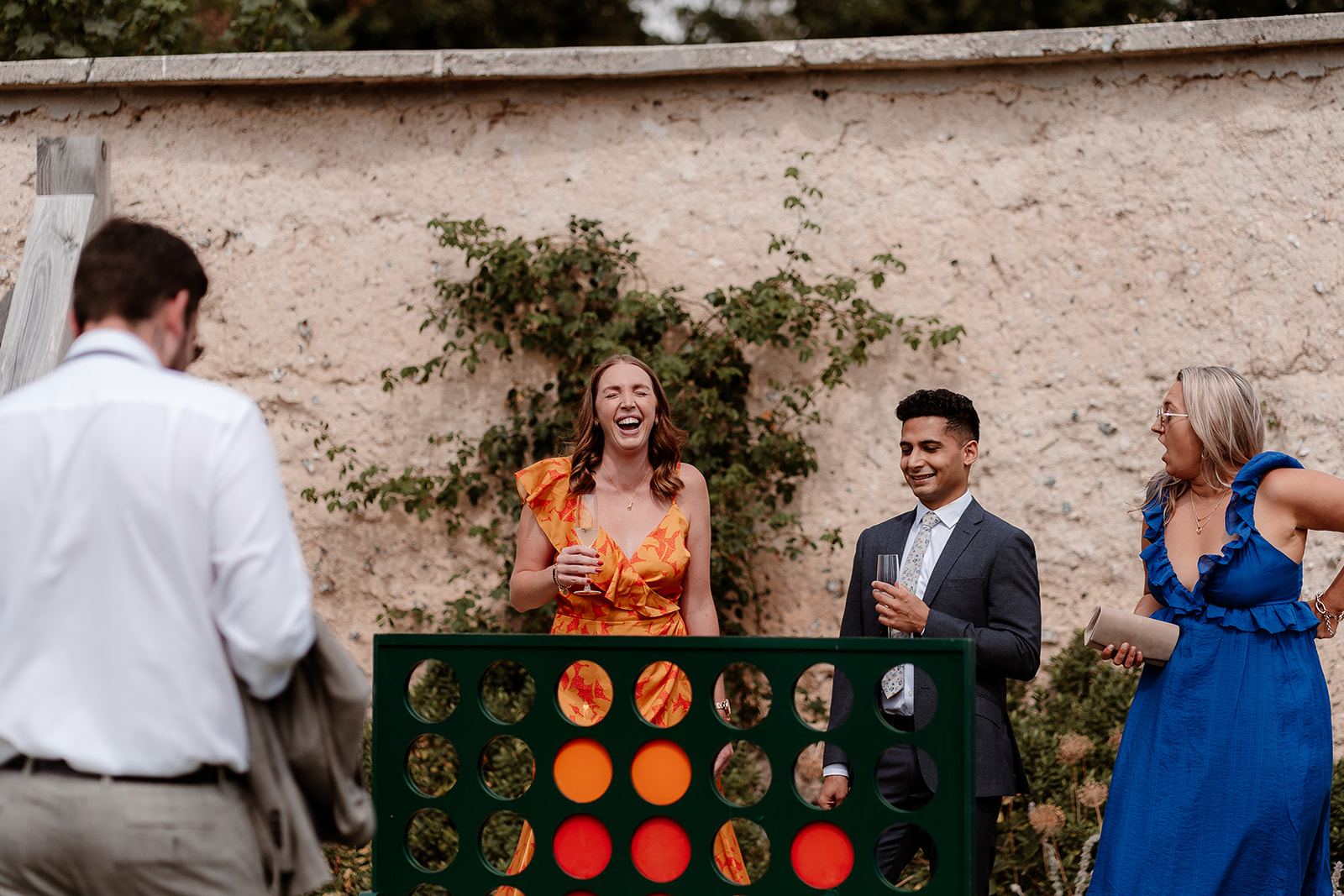 Guests enjoy games in the sunny Walled Garden at this summer Syrencot wedding.