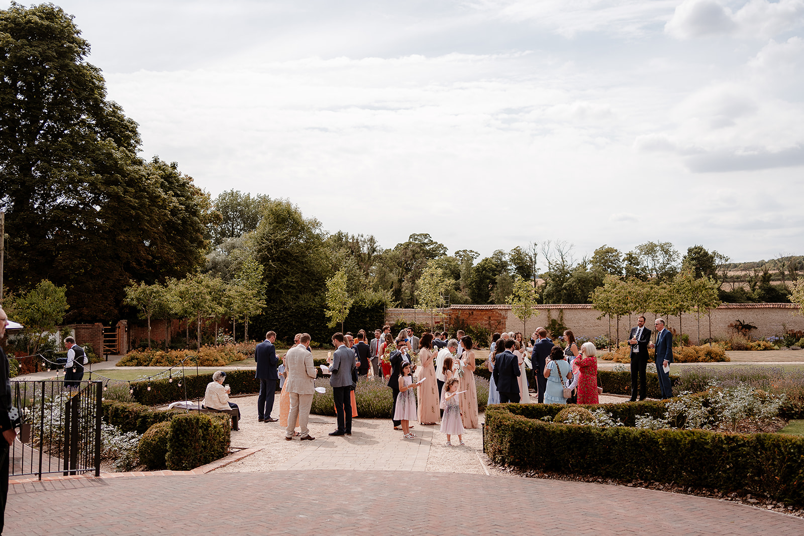 Guests enjoy games in the sunny Walled Garden at this summer Syrencot wedding.
