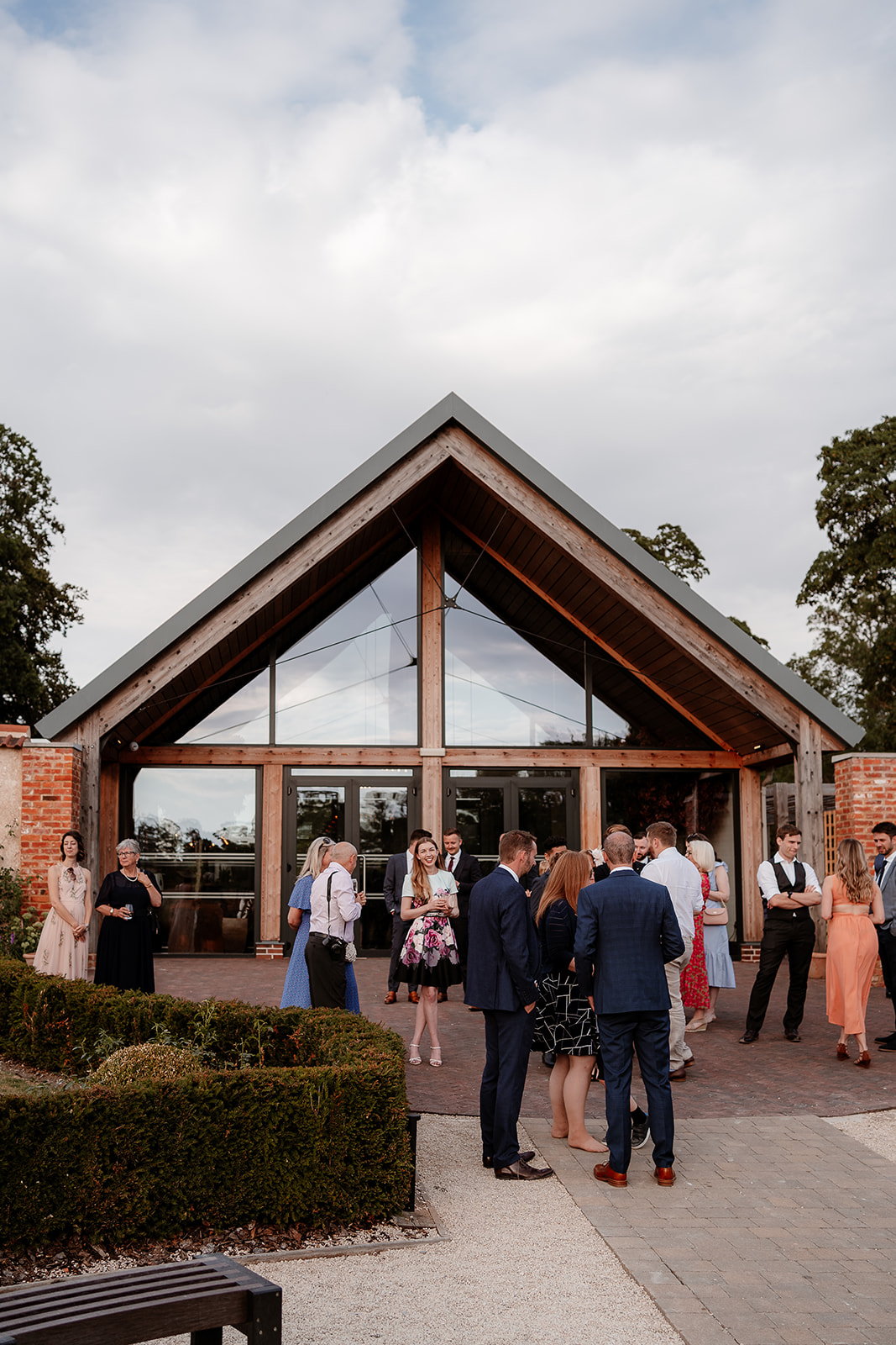 Guests enjoying the warm evening in the walled garden at this Syrencot wedding
