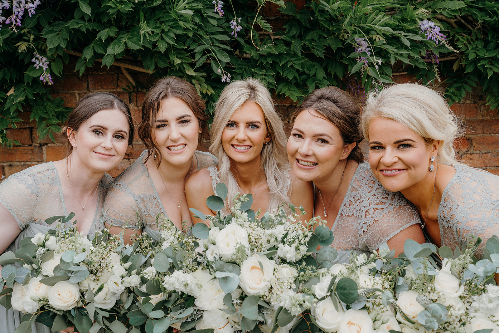 Bridesmaids all together with big smiles on their faces.