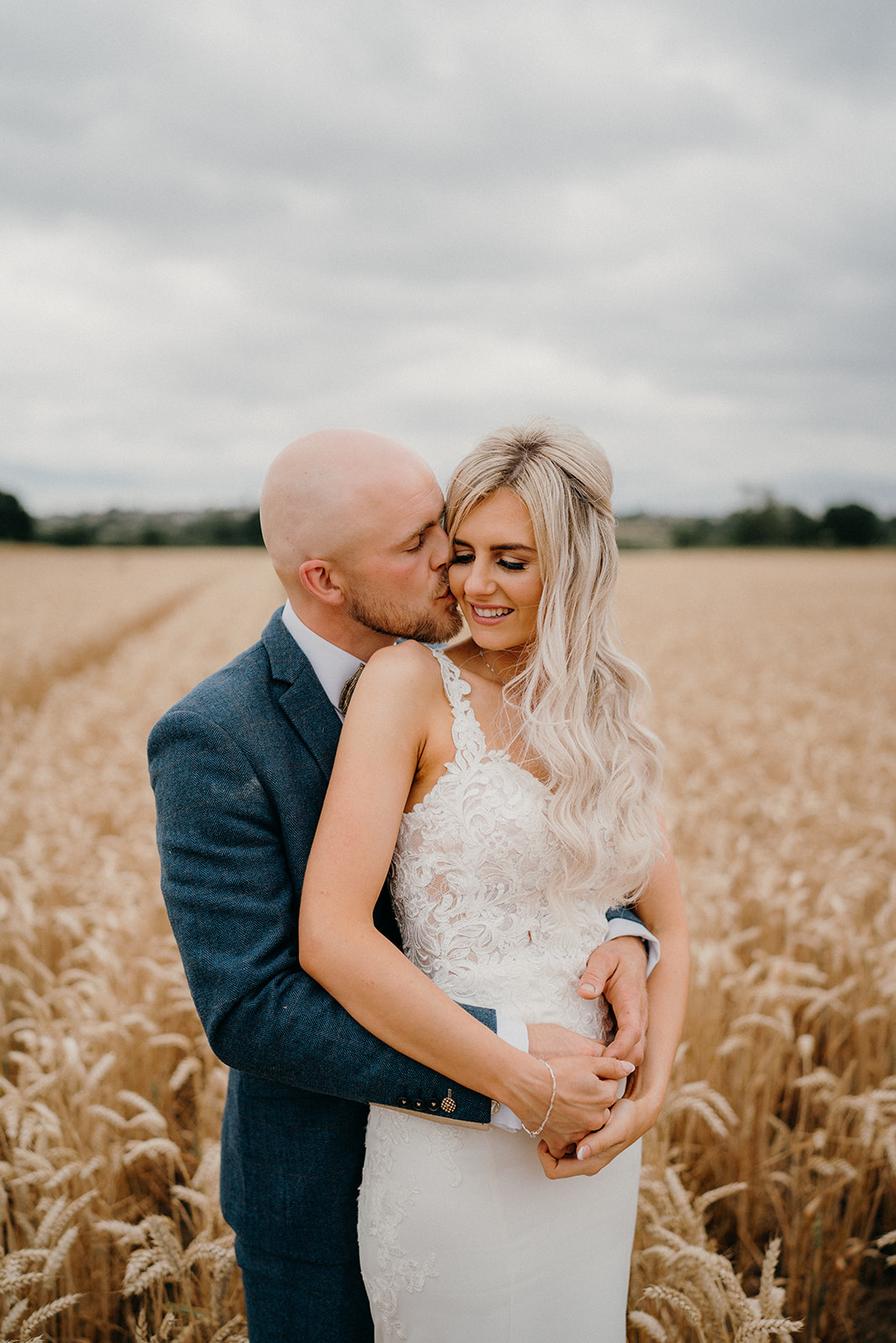 Bride and groom in the barley fields in a romantic, natural portrait.