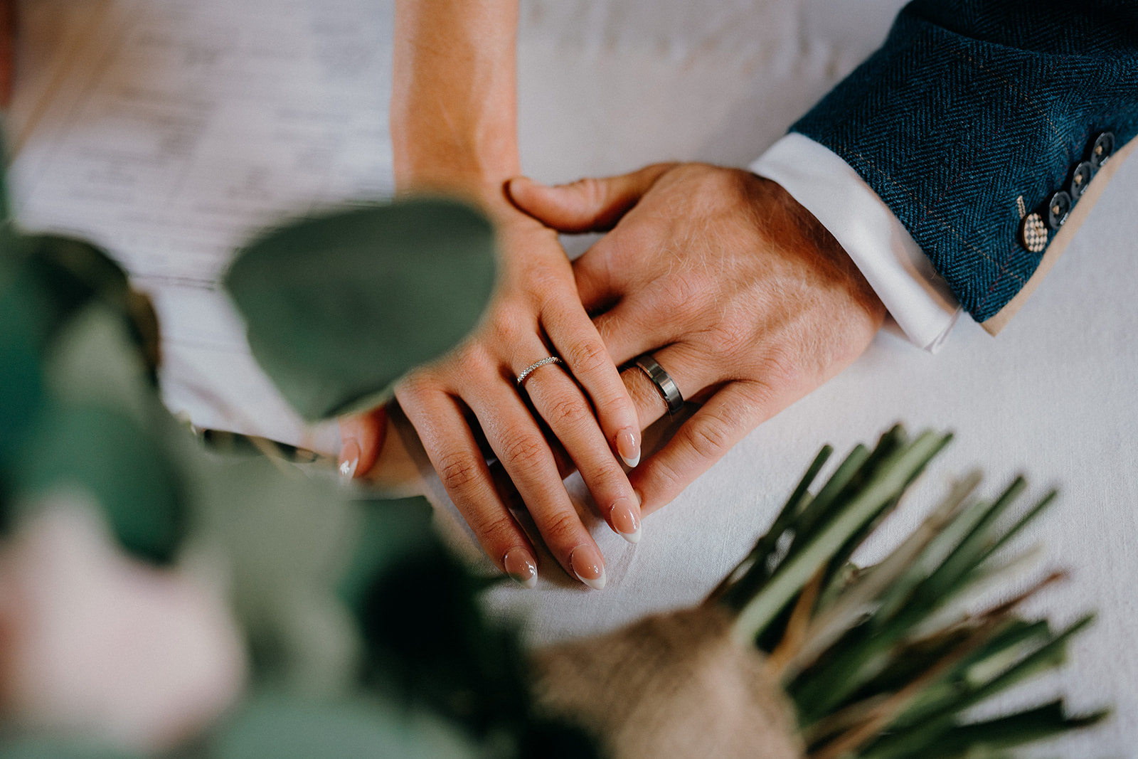 Bride and Grooms hands together showing their wedding rings.