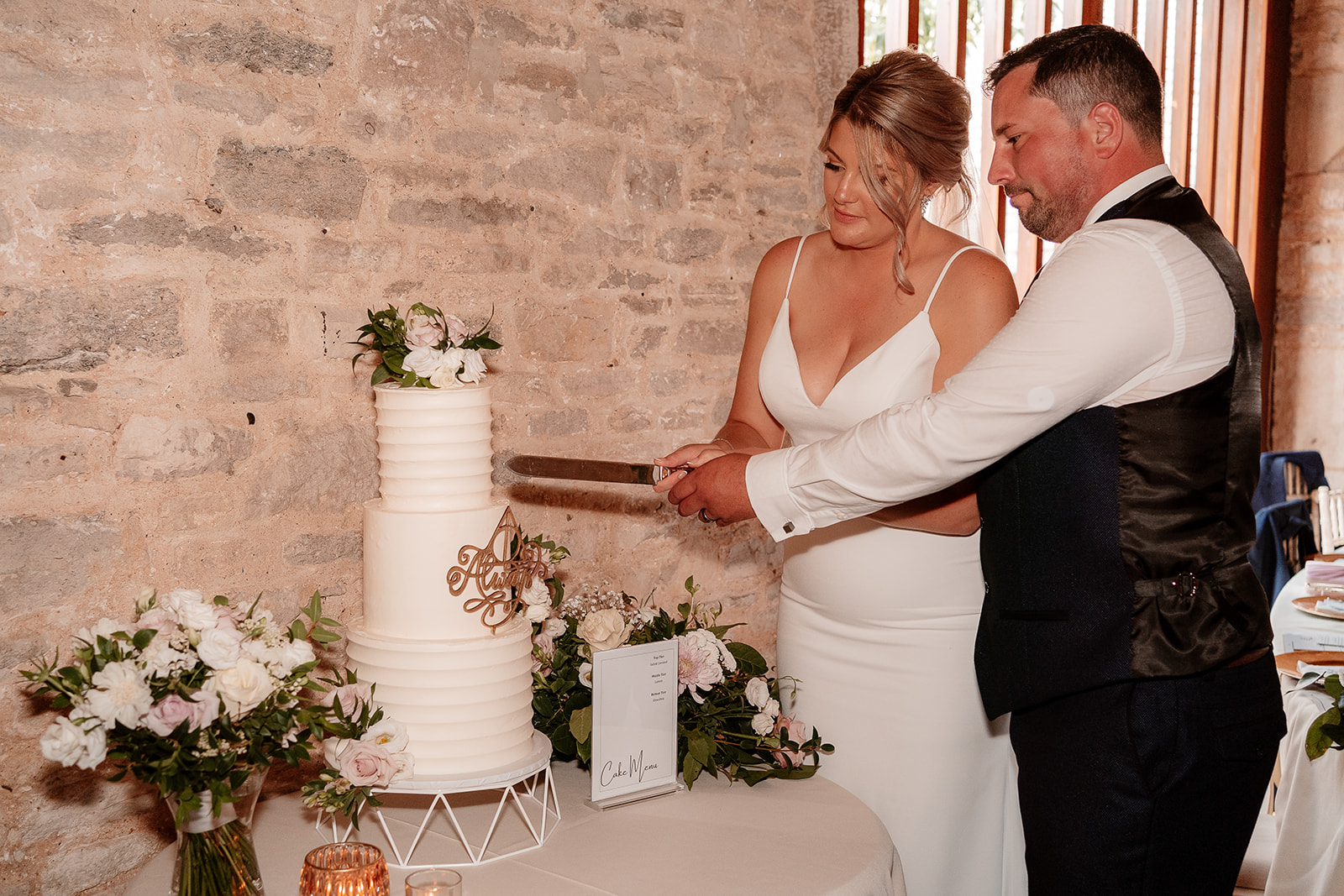 cake cut in the rustic barn for a Kingston Country Courtyard wedding
