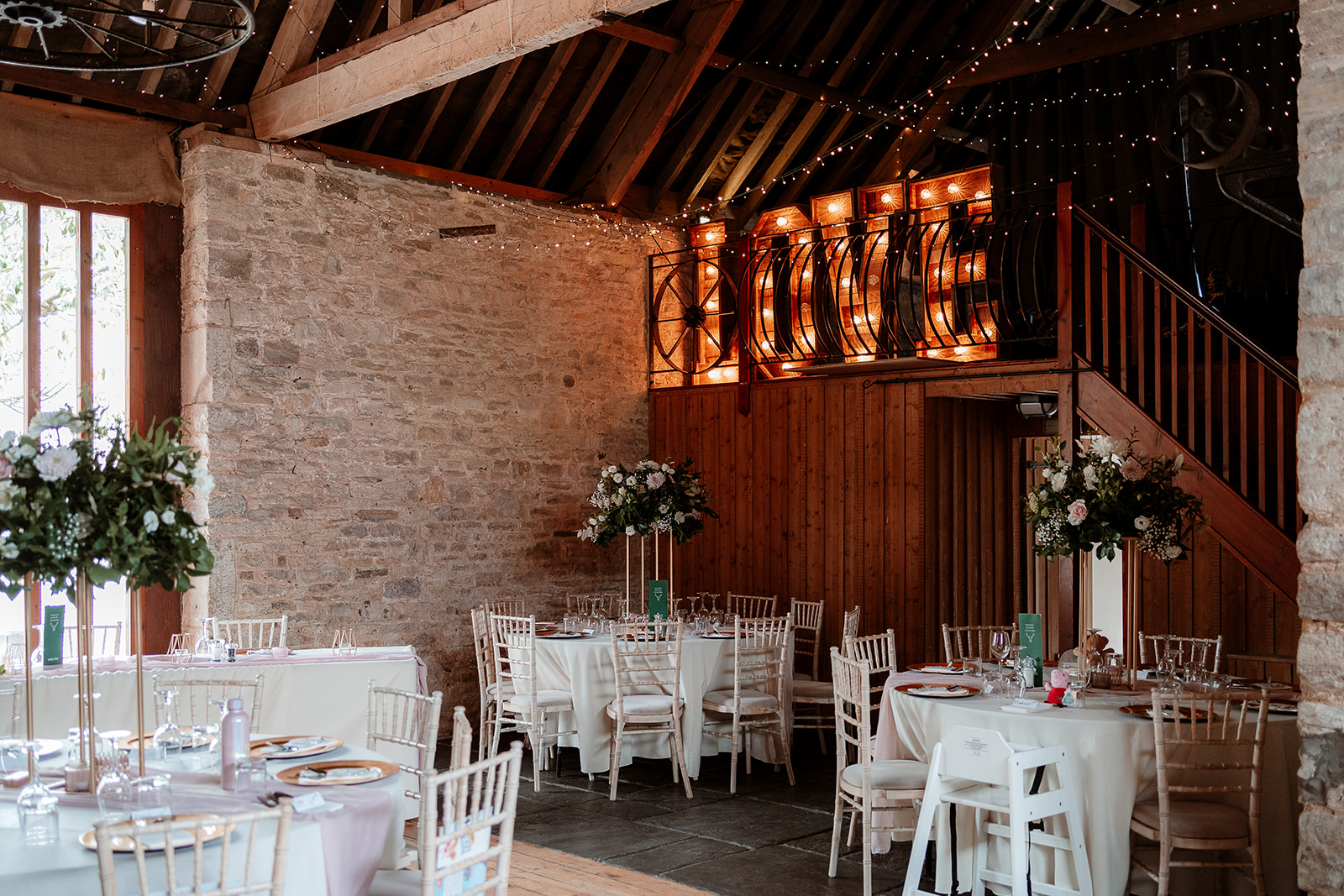 Cosy rustic barn set up for a wedding breakfast at Kingston Country Courtyard with fairy light canopy 