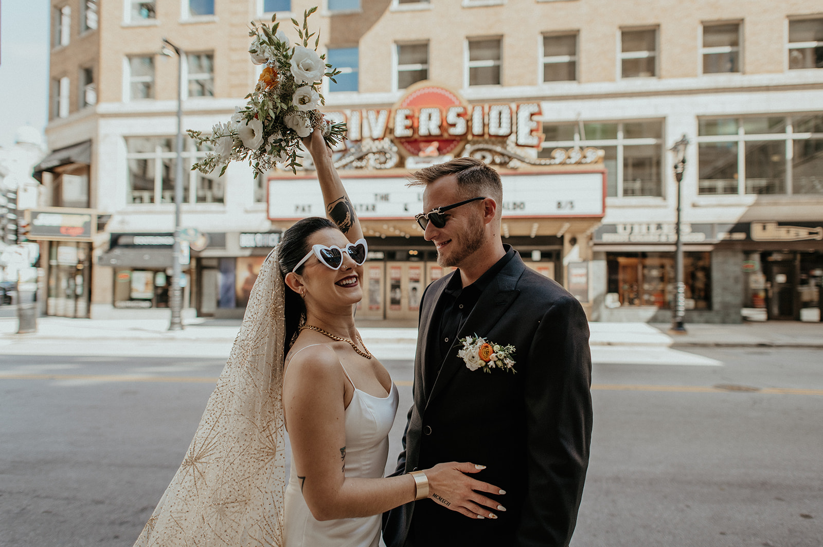 Bride and Groom pose together for portrait in Downtown Milwaukee in front of theatre