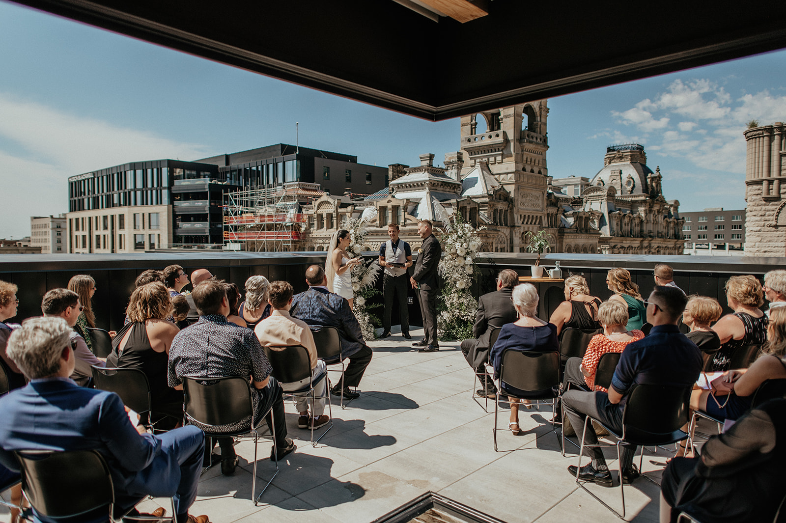 Bride and groom share vows during wedding ceremony on rooftop in Milwaukee